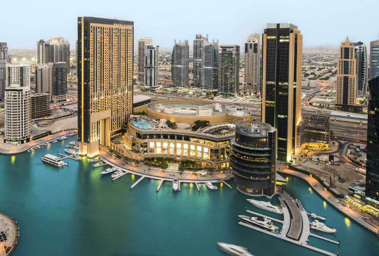 高層ビルに囲まれた港に建つホテル