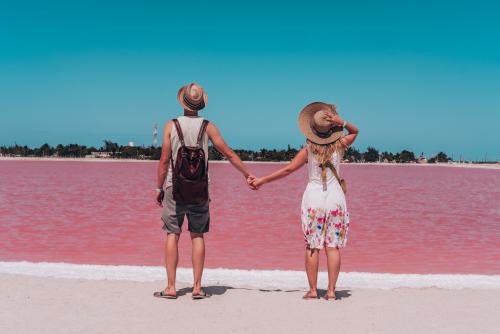 メキシコのピンクの湖の景色を楽しむ若い夫婦